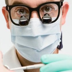 Dentist with his loops and face mask