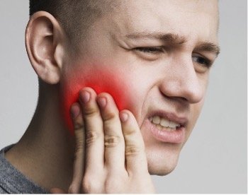 man touching his face in pain
